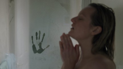 Elizabeth Moss takes a shower with a handprint in the steam.
