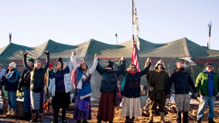 Activists celebrate at Oceti Sakowin Camp on the edge of the Standing Rock Sioux Reservation on December 4, 2016 outside Cannon Ball, North Dakota. The Army Corps of Engineers told Standing Rock Sioux Chairman Archambault Sunday that the current route for the Dakota Access pipeline will be denied. / AFP / JIM WATSON (Photo credit should read JIM WATSON/AFP via Getty Images)