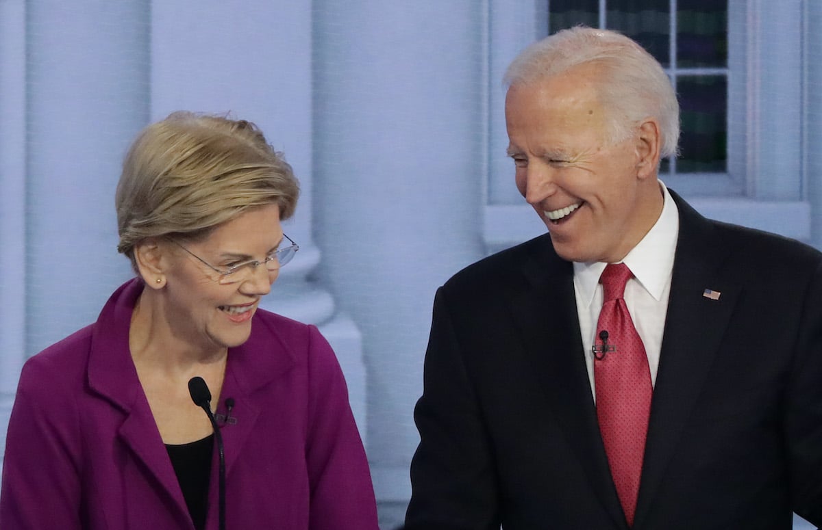 Elizabeth Warren and Joe Biden laugh during a debate.