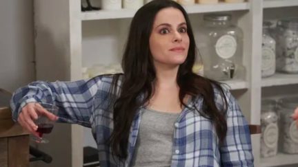 Stevie Budd holding a wine glass, making a face of disbelief on CBC's Schitt's Creek.