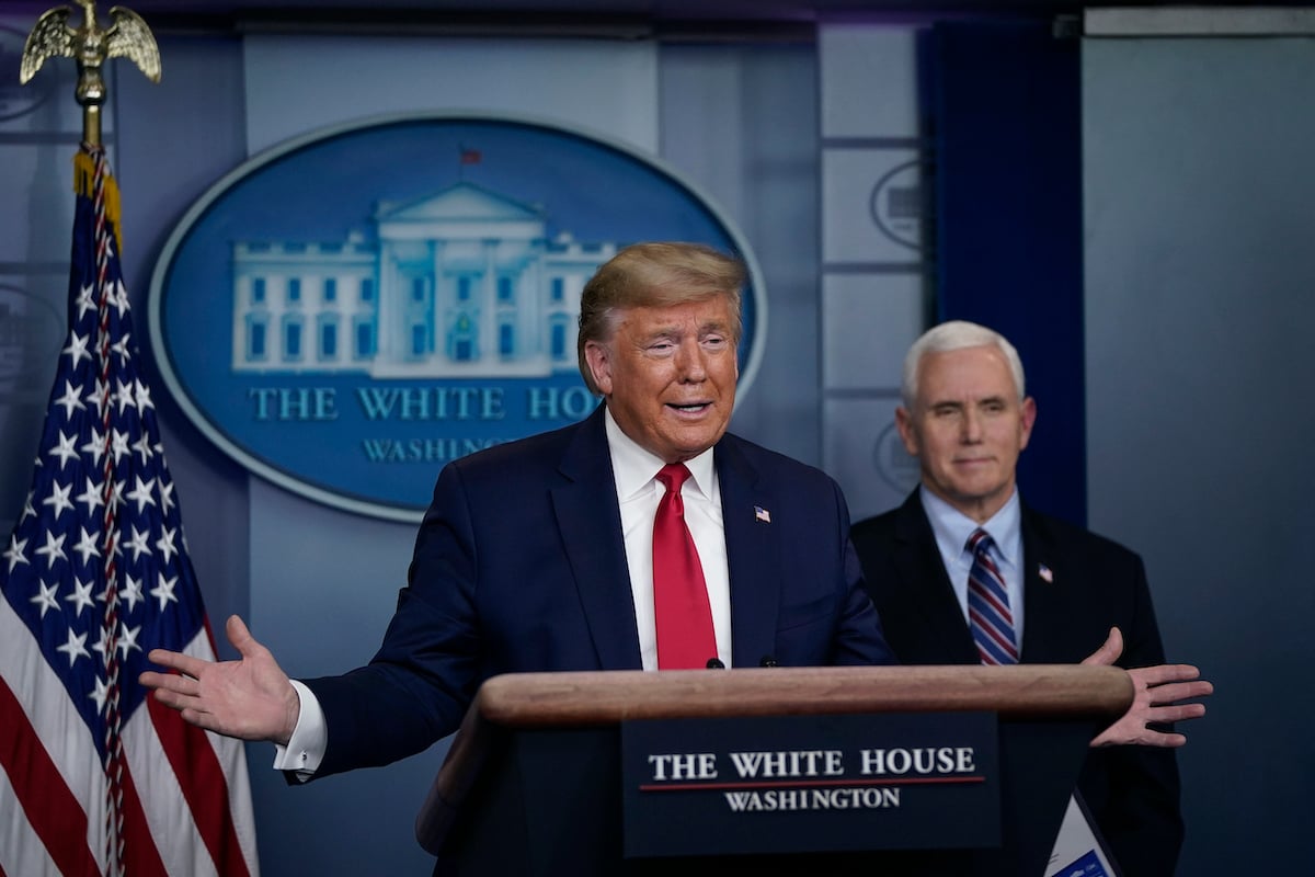 Donald Trump speaks as Vice President Mike Pence looks on during a briefing on the coronavirus pandemic in the press briefing room of the White House
