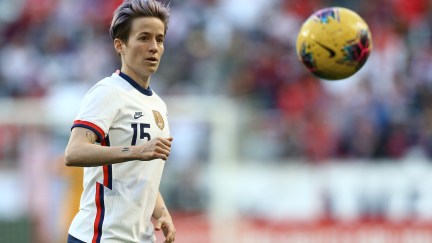 Megan Rapinoe on the soccer field with a soccer ball in the foreground.