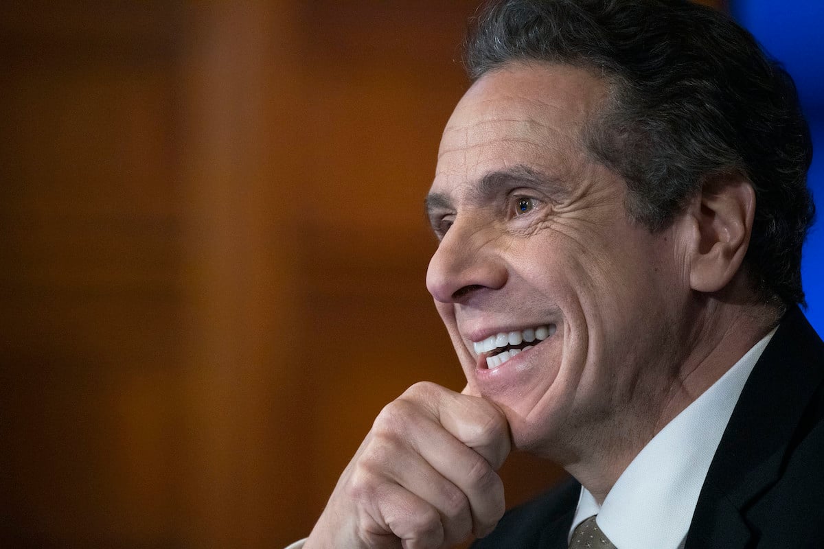 Andrew Cuomo smiles during a press briefing.