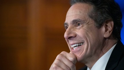 Andrew Cuomo smiles during a press briefing.