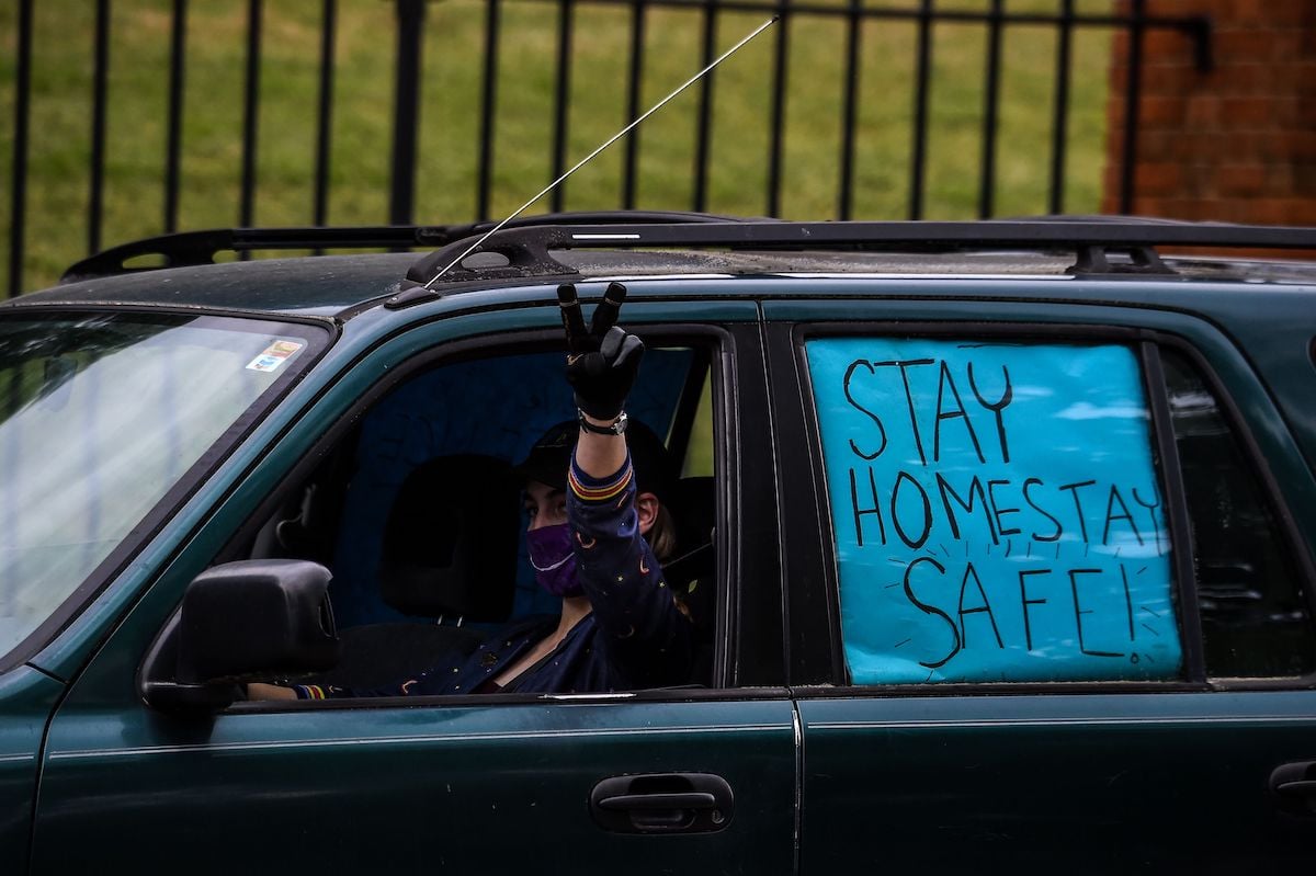 A protestor shows a sign while driving past the Governor's Mansion during a drive by protest in Atlanta, Georgia