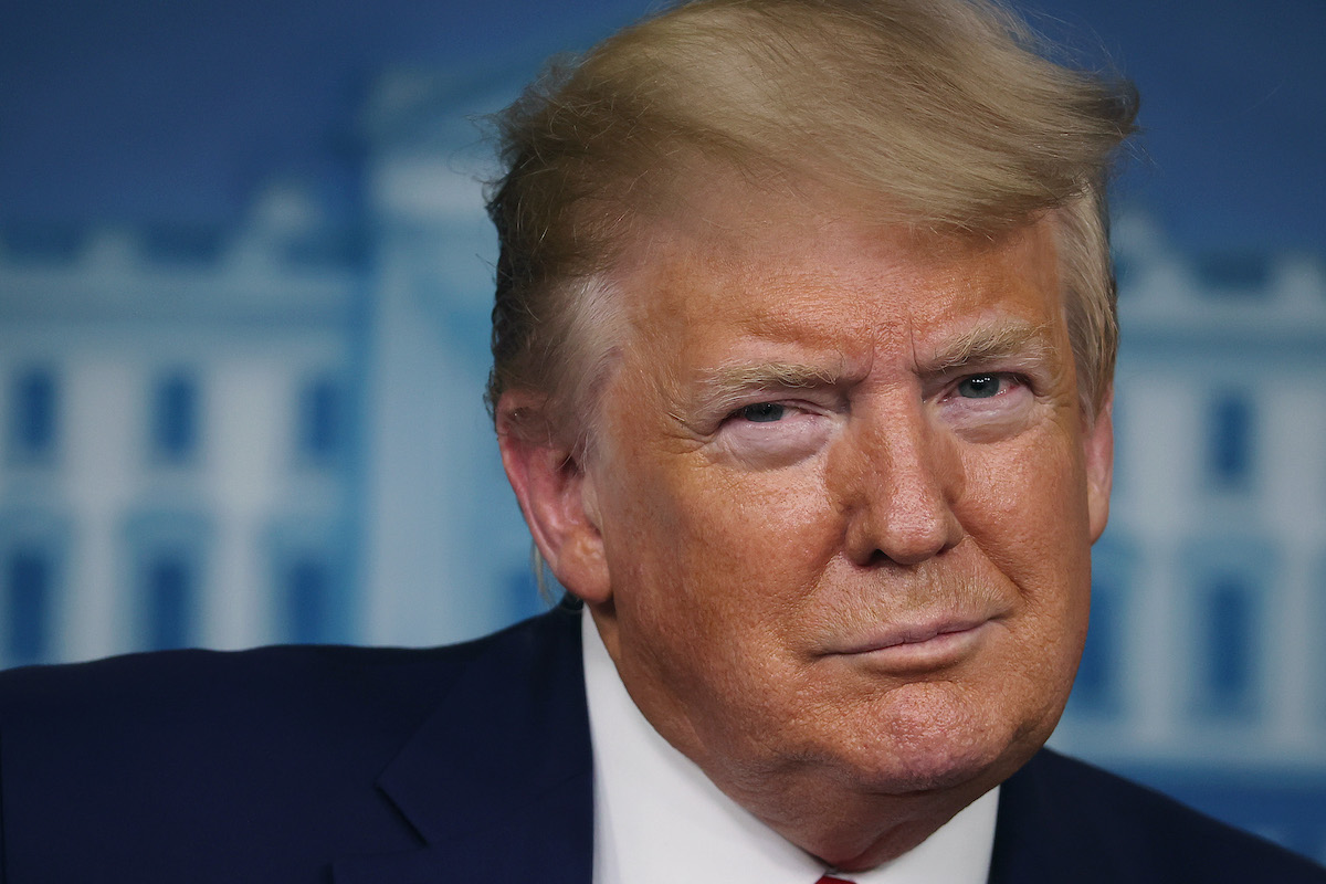 Donald Trump smirks during a press briefing.