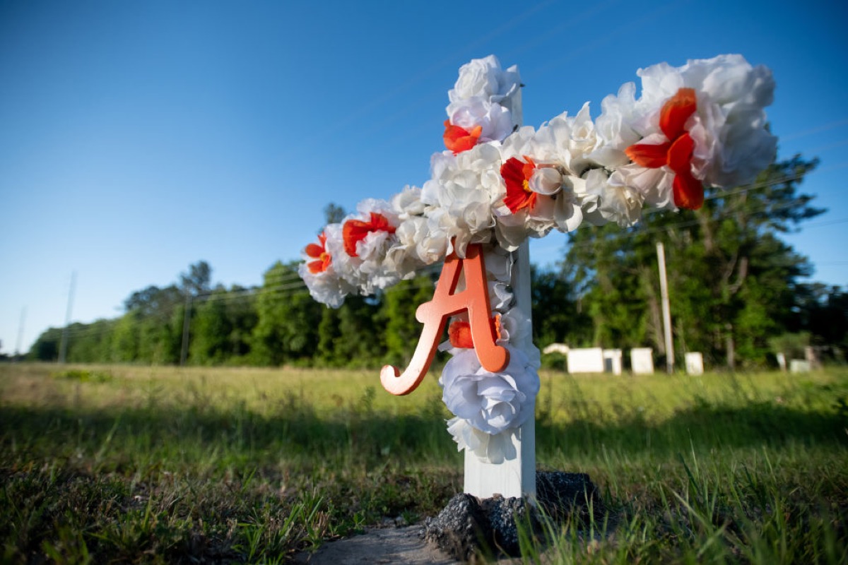 BRUNSWICK, GA - MAY 07: A cross with flowers and a letter A sits at the entrance to the Satilla Shores neighborhood where Ahmaud Arbery was shot and killed  May 7, 2020 in Brunswick, Georgia. Arbery was shot during  a confrontation with an armed father and son on Feb 23. (Photo by Sean Rayford/Getty Images)