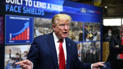 US President Donald Trump holds a mask instead of wearing it as he speaks during a tour of the Ford Rawsonville Plant in Ypsilanti, Michigan