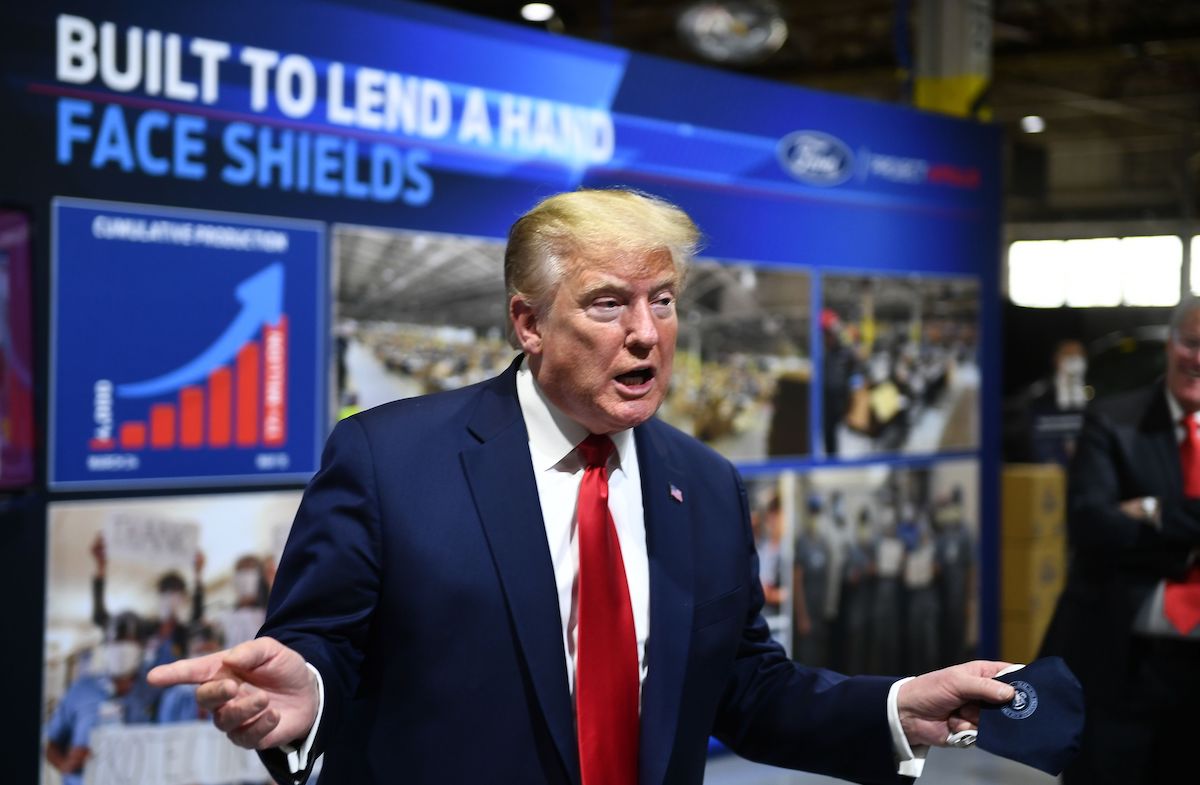 US President Donald Trump holds a mask instead of wearing it as he speaks during a tour of the Ford Rawsonville Plant in Ypsilanti, Michigan