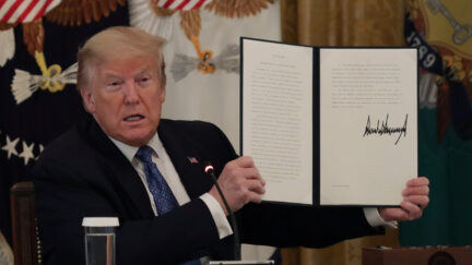 WASHINGTON, DC - MAY 19: U.S. President Donald Trump holds up a copy of an executive order he signed on DOT deregulation, during a meeting with his cabinet in the East Room of the White House on May 19, 2020 in Washington, DC. Earlier in the day President Trump met with members of the Senate GOP. (Photo by Alex Wong/Getty Images)
