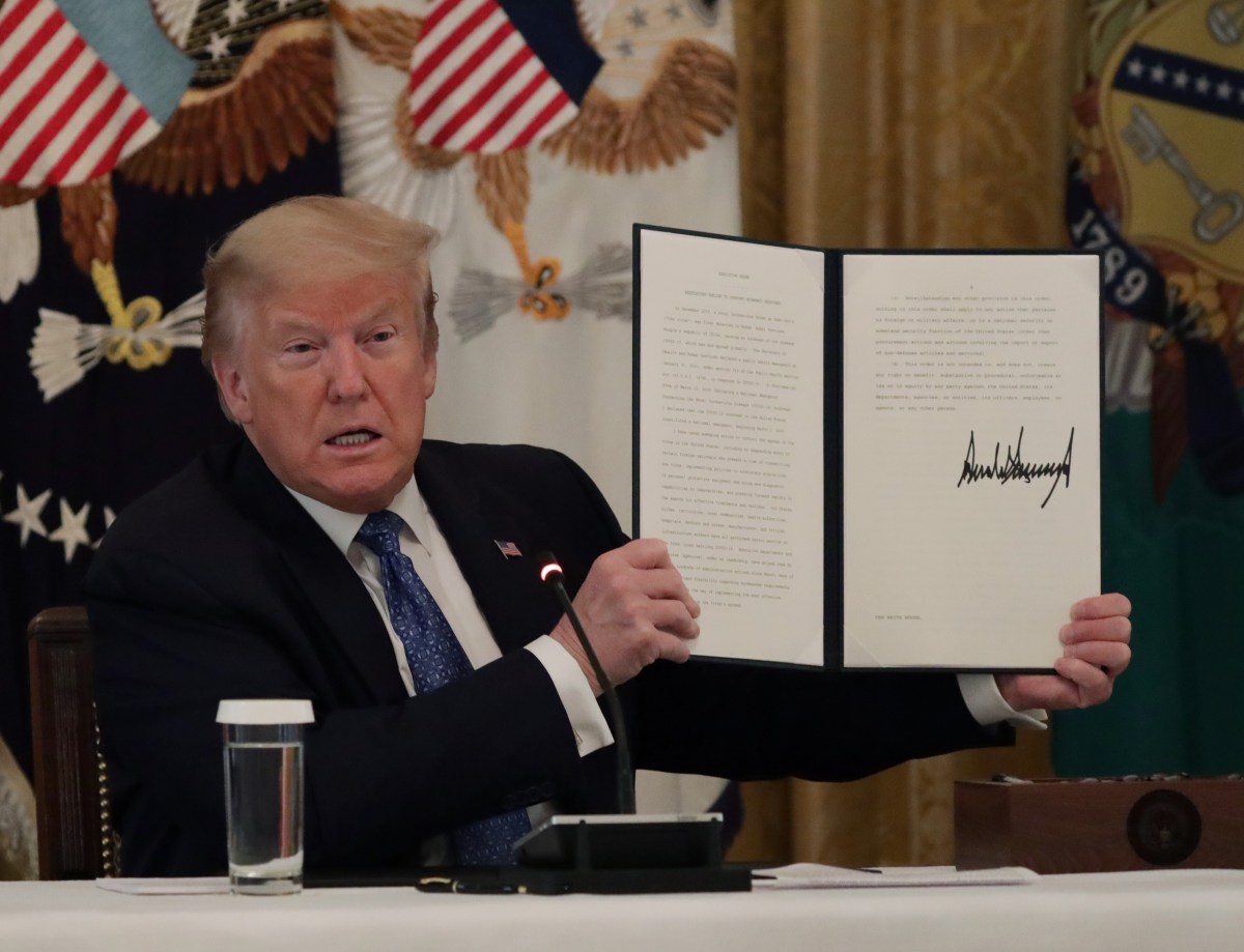 WASHINGTON, DC - MAY 19: U.S. President Donald Trump holds up a copy of an executive order he signed on DOT deregulation, during a meeting with his cabinet in the East Room of the White House on May 19, 2020 in Washington, DC. Earlier in the day President Trump met with members of the Senate GOP. (Photo by Alex Wong/Getty Images)