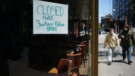 People walk through a shuttered business district