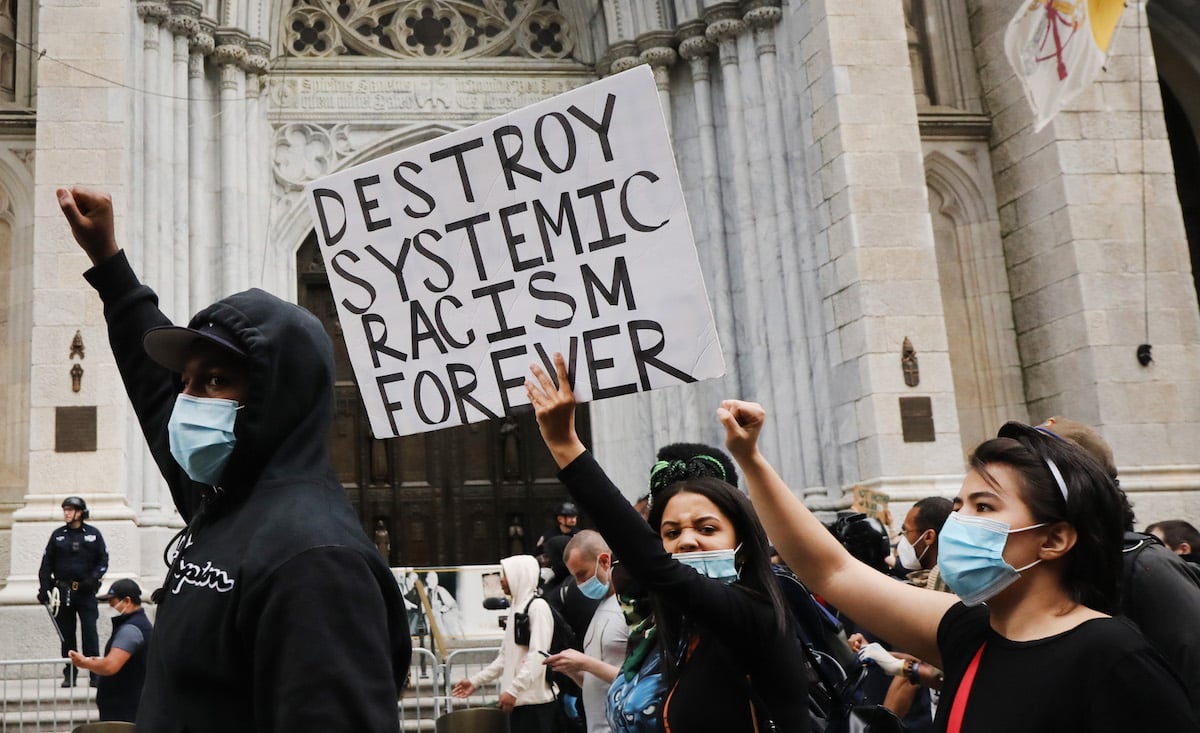 George Floyd Black Lives Matter protestors hold "destroy systemic racism forever" sign.