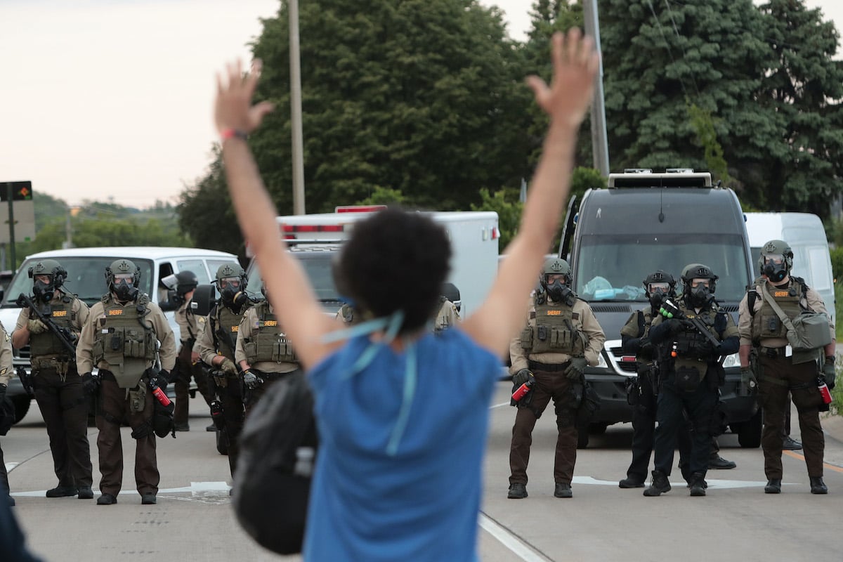 A demonstrator holds her hands up in front of police while protesting against the death of George Floyd