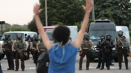 A demonstrator holds her hands up in front of police while protesting against the death of George Floyd