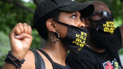 WASHINGTON, DC - JUNE 19: People kneel and raise their fists in the air for eight minutes and 46 seconds -- the time that George Floyd was pinned under a police officer's knee -- during a march and protest to mark the Juneteenth holiday at the Martin Luther King Jr. Memorial June 19, 2020 in Washington, DC. Juneteenth commemorates June 19, 1865, when a Union general read orders in Galveston, Texas stating all enslaved people in Texas were free according to federal law, effectively ending slavery in what remained of the Confederacy. (Photo by Chip Somodevilla/Getty Images)