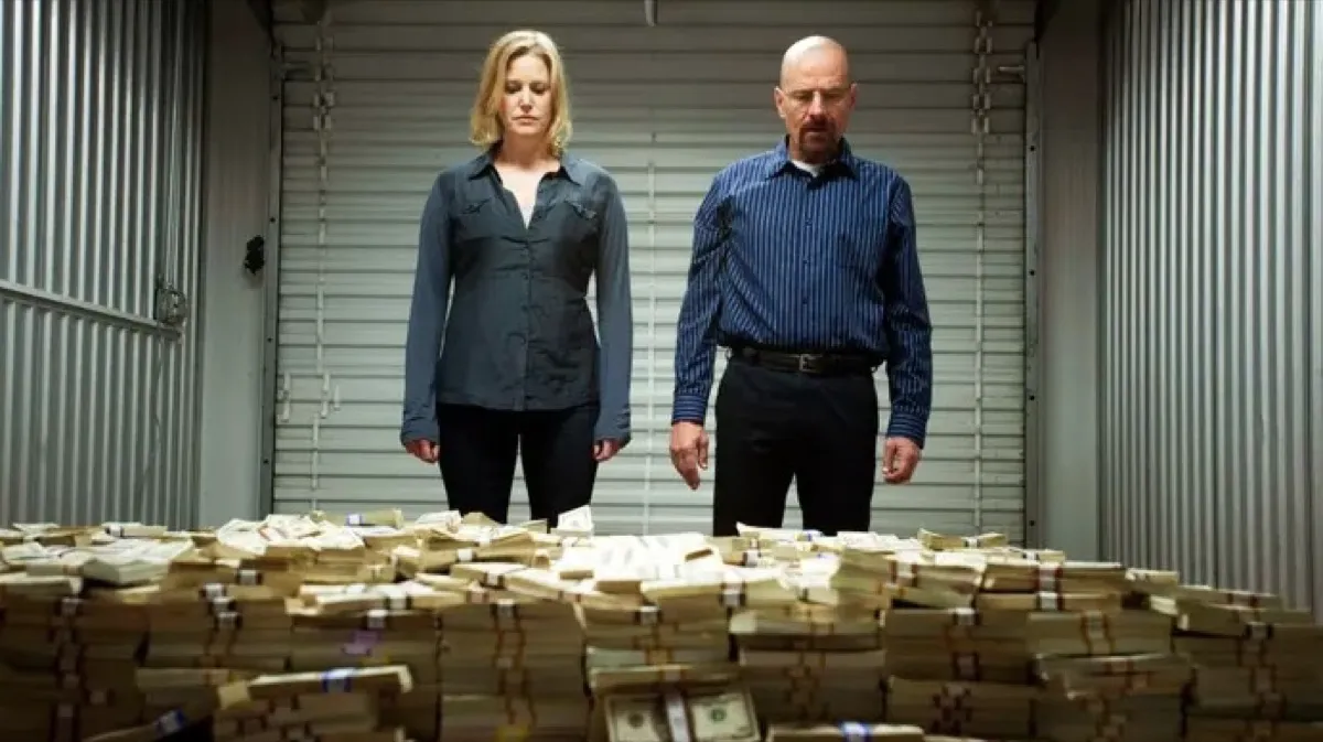 Skyler and Walter White staring at a massive pile of money in a storage unit on AMC's Breaking Bad.