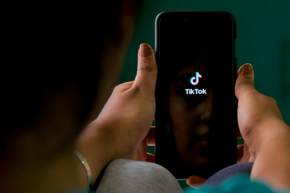 An Indian mobile user browses through the Chinese owned video-sharing 'Tik Tok' app on a smartphone in Bangalore on June 30, 2020. - TikTok on June 30 denied sharing information on Indian users with the Chinese government after New Delhi banned the wildly popular app citing national security and privacy concerns. "TikTok continues to comply with all data privacy and security requirements under Indian law and have not shared any information of our users in India with any foreign government, including the Chinese Government," said the company, which is owned by China's ByteDance. (Photo by Manjunath Kiran / AFP) (Photo by MANJUNATH KIRAN/AFP via Getty Images)
