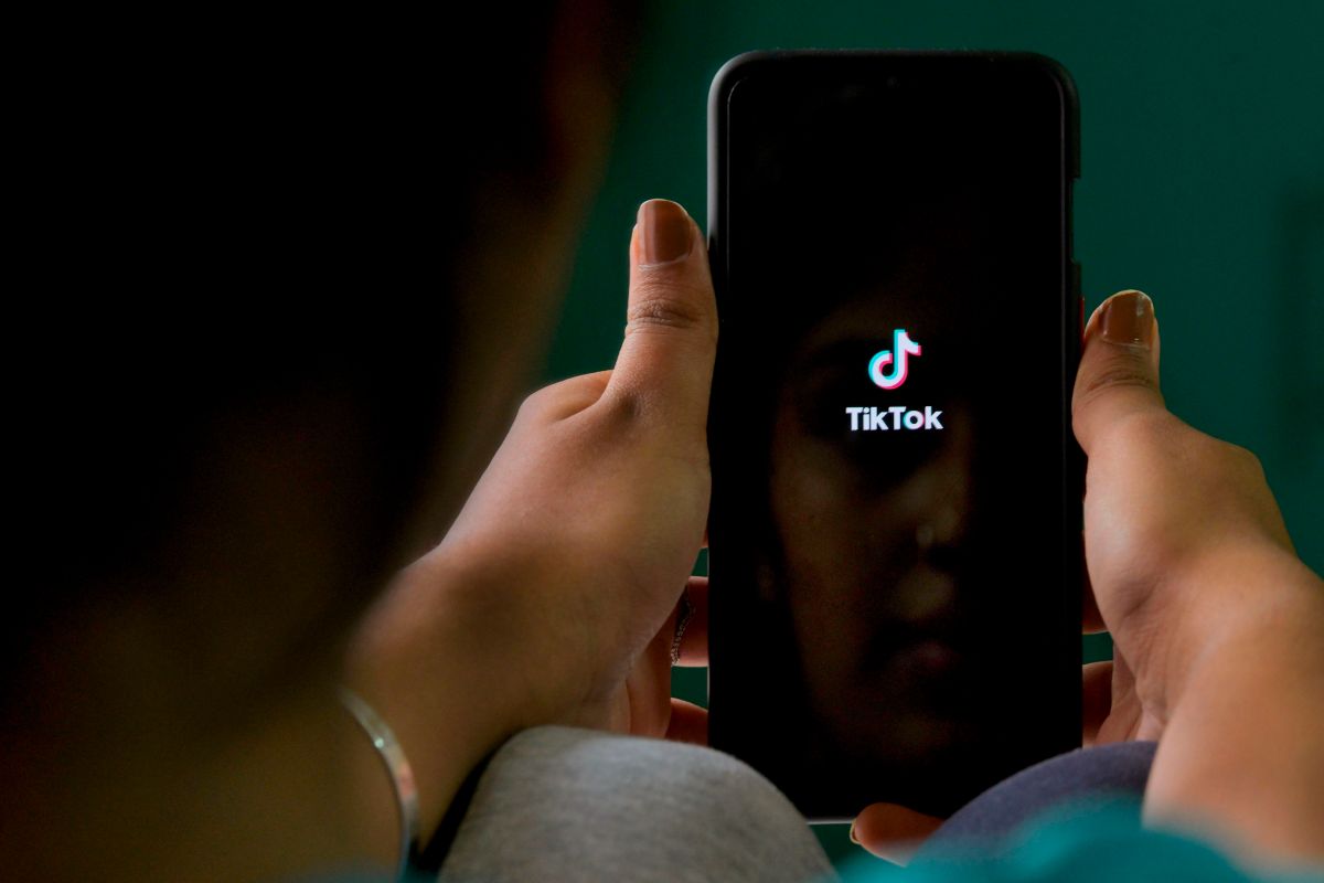 Hands holding a phone with tik tok logo (Photo by MANJUNATH KIRAN/AFP via Getty Images)