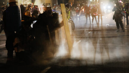 PORTLAND, OREGON - JULY 28: Protesters clash with federal police in front of the Mark O. Hatfield federal courthouse in downtown Portland as the city experiences another night of unrest on July 28, 2020 in Portland, Oregon. For over 57 straight nights, protesters in downtown Portland have faced off in often violent clashes with the Portland Police Bureau and, more recently, federal officers. The demonstrations began to honor the life of George Floyd and other black Americans killed by law enforcement and have intensified as the Trump administration called in the federal officers. (Photo by Spencer Platt/Getty Images)