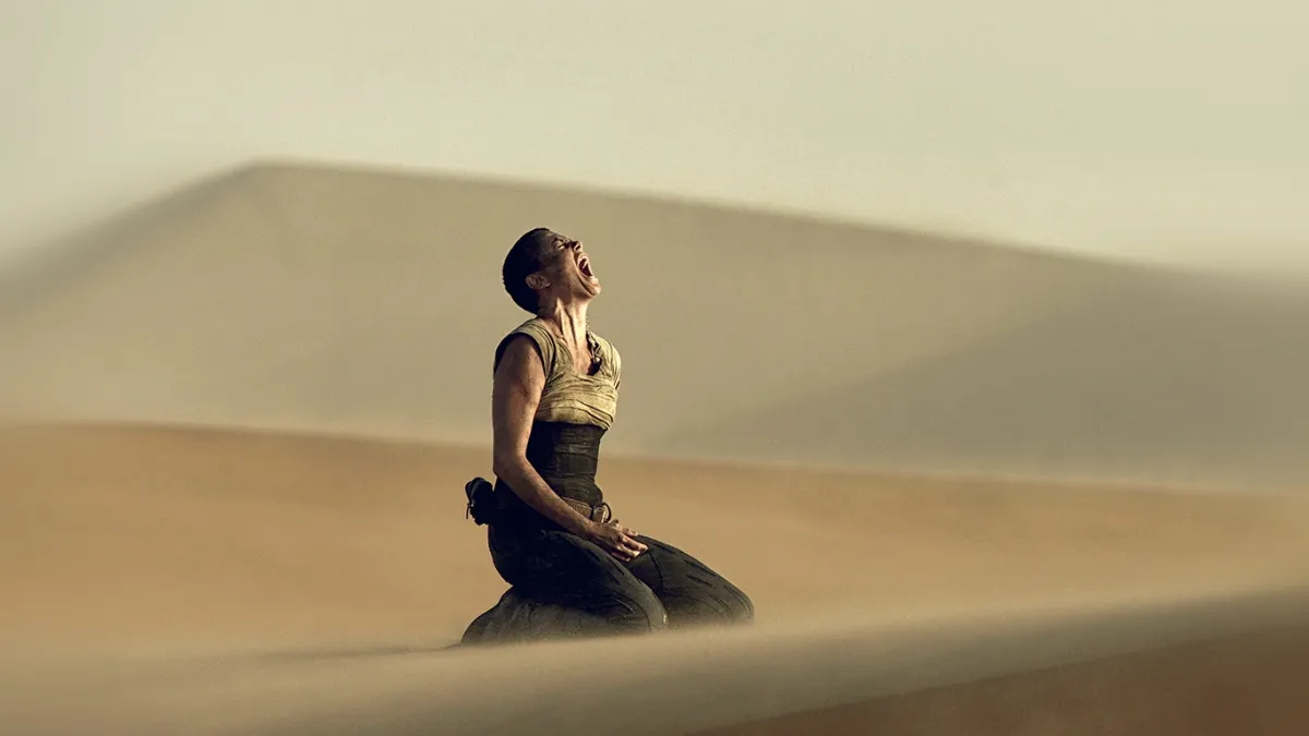 A bald woman on her knees screaming into the sky in "Mad Max: Fury Road"