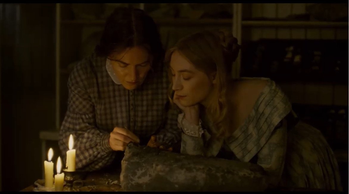 kate winslet and saorise ronan look longingly at a rock and eachother