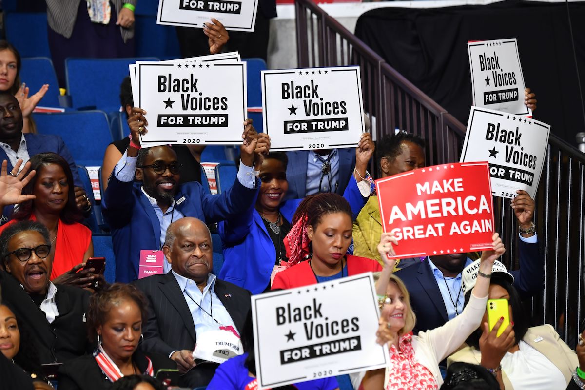 Herman Cain and supporters of US President Donald Trump "Black Voices" listen to him speak during a campaign rally