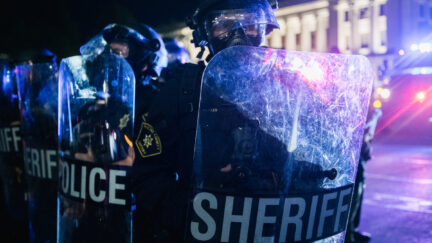 A row of police officers holding shields in Kenosha, Wisconsin.