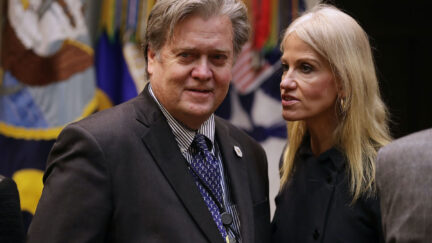 Kellyanne Conway talks into Steve Bannon's ear.