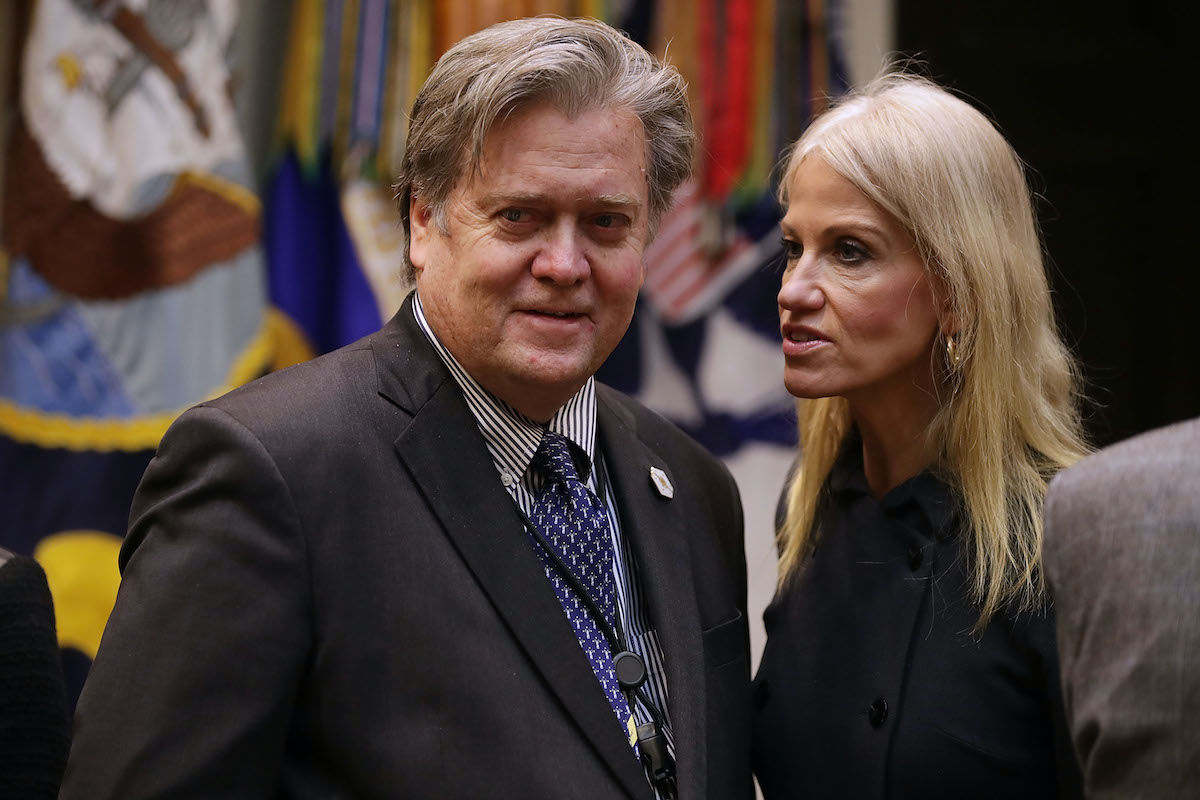 Kellyanne Conway talks into Steve Bannon's ear.