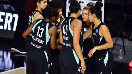 The New York Liberty starters huddle before a game, wearing jerseys bearing Breonna Taylor's name.