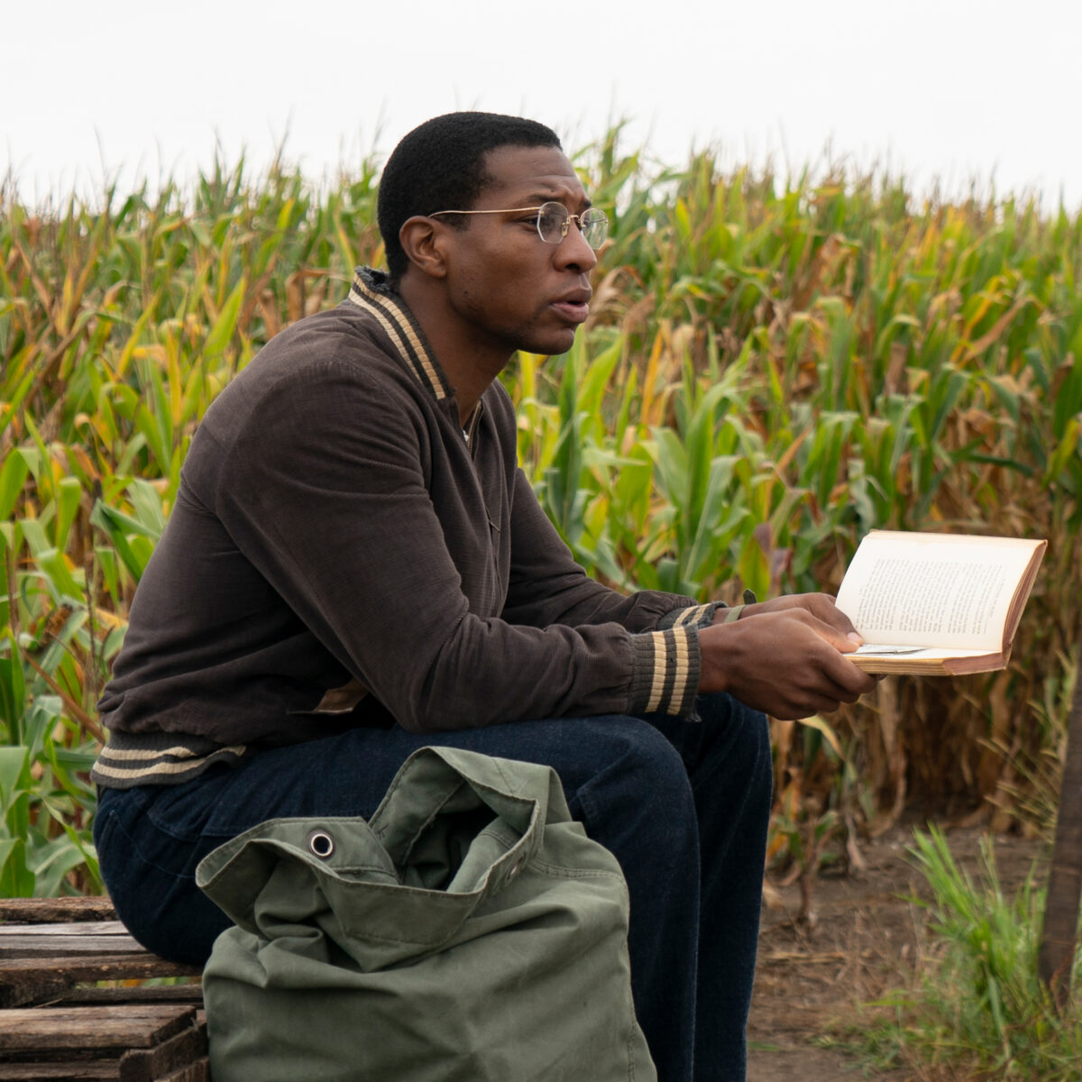 Atticus Black holding a book in HBO's Lovecraft Country.