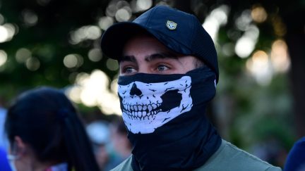 A demonstrator covers his face with a neck gaiter as he takes part in a demonstration against the government's handling of the coronavirus crisis, on May 20, 2020, in Alcorcon, near Madrid. - Spain's prime minister won parliamentary backing extend the lockdown for another two weeks today, despite opposition from his rightwing opponents and protests against his minority coalition government. It was the fifth time the state of emergency has been renewed, meaning the restrictions will remain in force until June 6 in a measure passed by 177 votes in favour, 162 against and 11 abstentions. (Photo by JAVIER SORIANO / AFP) (Photo by JAVIER SORIANO/AFP via Getty Images)