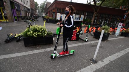 Anarchy! A woman wears a mask as she rides a scooter in downtown Portland, Oregon where air quality due to smoke from wildfires was measured to be amongst the worst in the world, September 14, 2020. - The deadly fires spreading across three western US states are causing record-breaking pollution and a spate of health woes, from headaches and coughs to impaired vision, that have residents worried about the long-term consequences. Portland, the largest city in Oregon, has been blanketed for days by a dense smog that has sent pollution meters soaring. (Photo by Robyn Beck / AFP) / TO GO WITH AFP STORY BY CYRIL JULIEN 