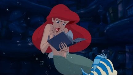 Ariel looking at a book in the animated 'The Little Mermaid'