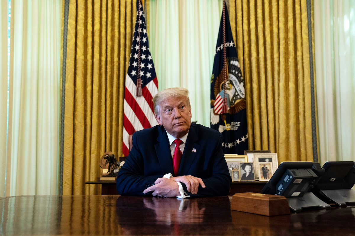 Donald Trump sits at his Oval Office desk.