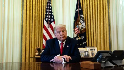 Donald Trump sits at his Oval Office desk.