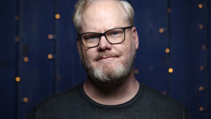 Jim Gaffigan in front of a blue background, looking at the camera.