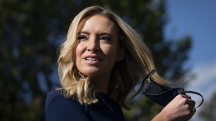White House Press Secretary Kayleigh McEnany takes off her face covering before speaking with reporters outside the West Wing of the White House