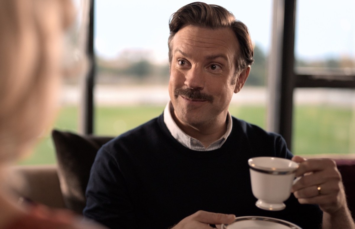 Ted Lasso holds a cup of tea.