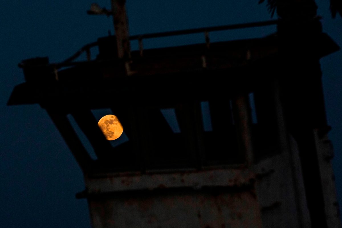 This picture taken on June 5, 2020 shows a view of the full moon during the "Strawberry Moon" lunar eclipse in the sky behind an old grounded boat, over Iraq's southern port city of Basra. (Photo by Hussein FALEH / AFP) (Photo by HUSSEIN FALEH/AFP via Getty Images)