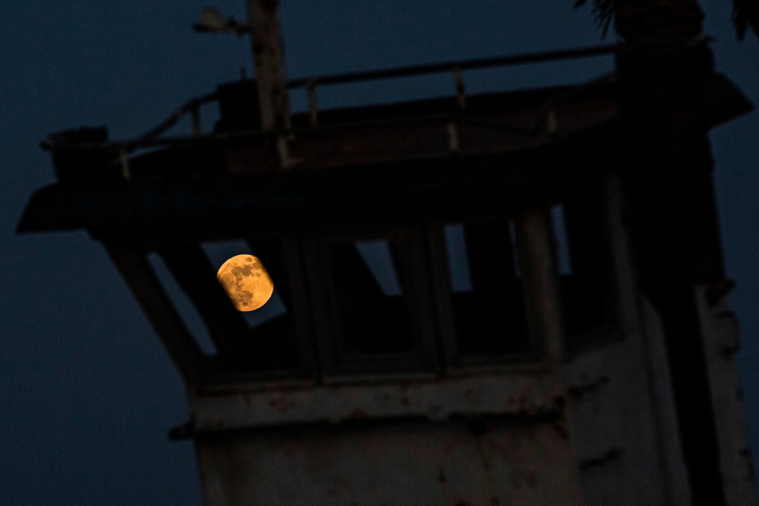 This picture taken on June 5, 2020 shows a view of the full moon during the "Strawberry Moon" lunar eclipse in the sky behind an old grounded boat, over Iraq's southern port city of Basra. (Photo by Hussein FALEH / AFP) (Photo by HUSSEIN FALEH/AFP via Getty Images)