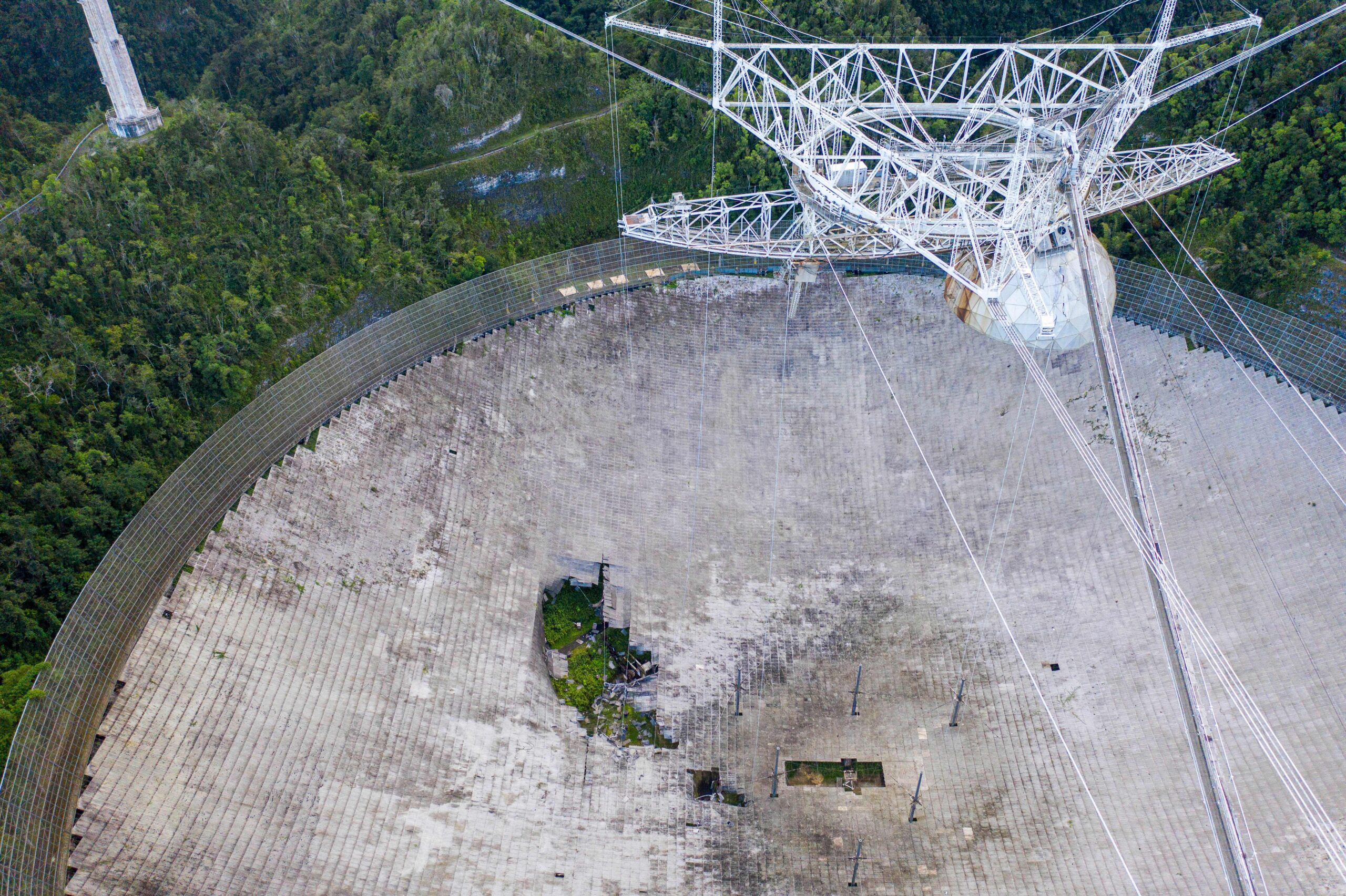 This aerial view shows a hole in the dish panels of the Arecibo Observatory in Arecibo, Puerto Rico, on November 19, 2020. - The National Science Foundation (NSF) announced on November 19, 2020, it will decommission the radio telescope following two cable breaks in recent months which have brought the structure to near collapse. (Photo by Ricardo ARDUENGO / AFP) (Photo by RICARDO ARDUENGO/AFP via Getty Images)