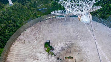 This aerial view shows a hole in the dish panels of the Arecibo Observatory in Arecibo, Puerto Rico, on November 19, 2020. - The National Science Foundation (NSF) announced on November 19, 2020, it will decommission the radio telescope following two cable breaks in recent months which have brought the structure to near collapse. (Photo by Ricardo ARDUENGO / AFP) (Photo by RICARDO ARDUENGO/AFP via Getty Images)