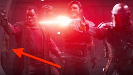 The Mandalorian screenshot of Mandalorian and crew firing while a man in jeans, Jeans Guy, Jean Rolex, JG-56, stands behind them.