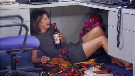 robin under a desk drinking wine and crying