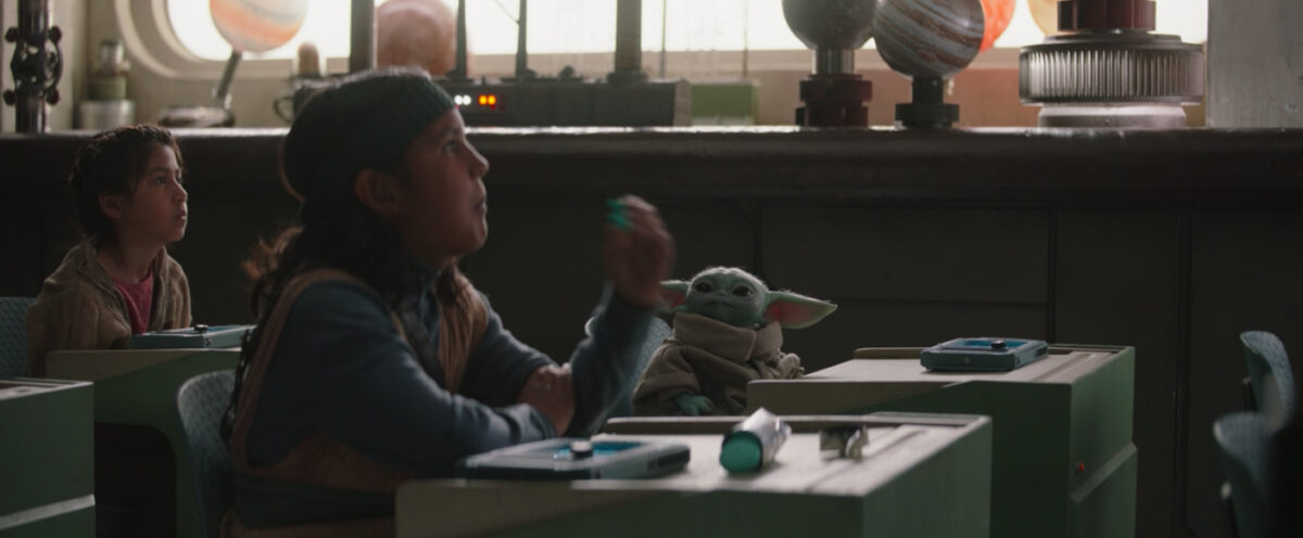 baby yoda watching a kid eat macaroons