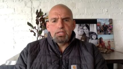 John Fetterman appears on MSNBC in front of pictures of his family.