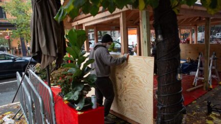 Workers build up a outdoor area outside a restaurant in New York