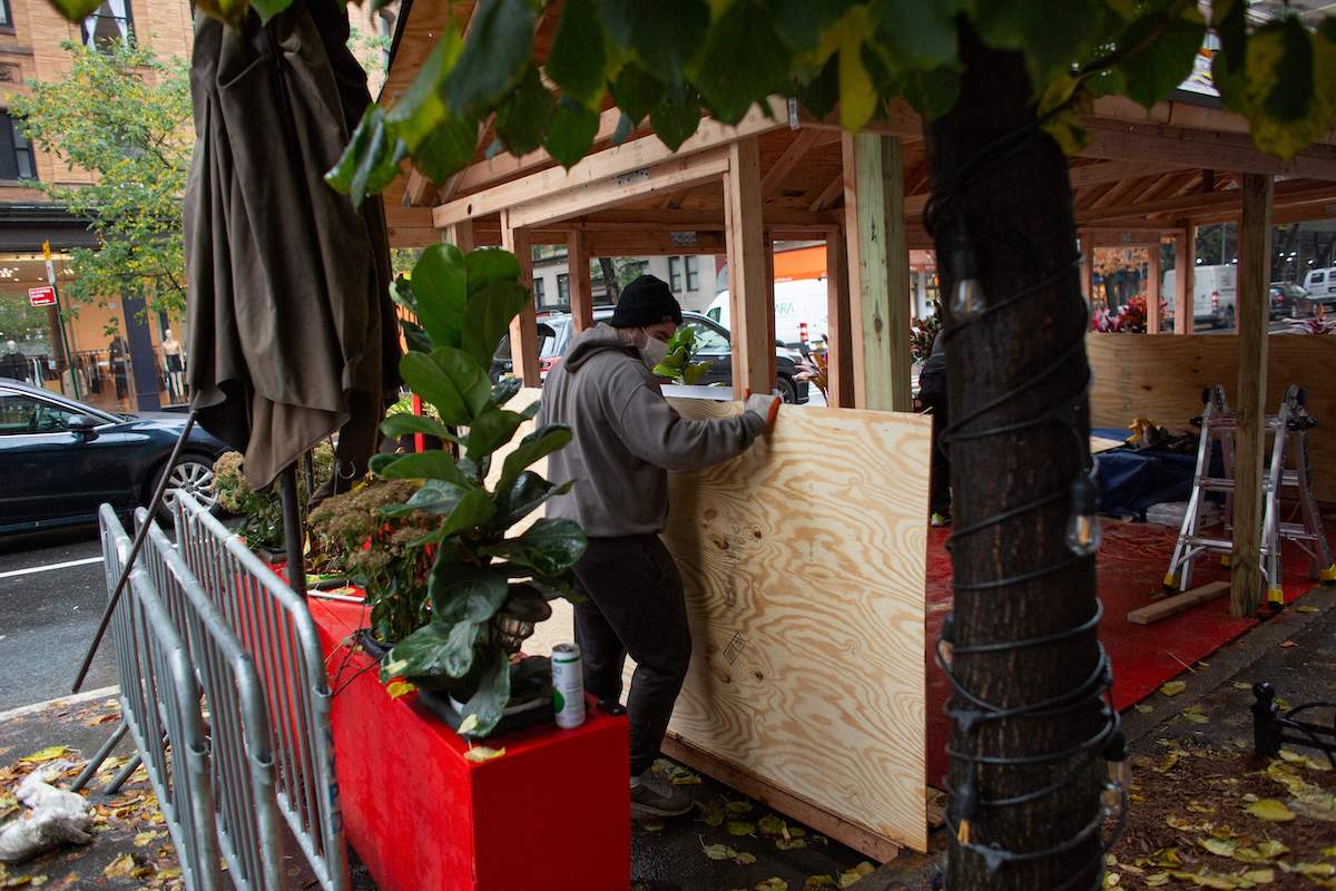 Workers build up a outdoor area outside a restaurant in New York